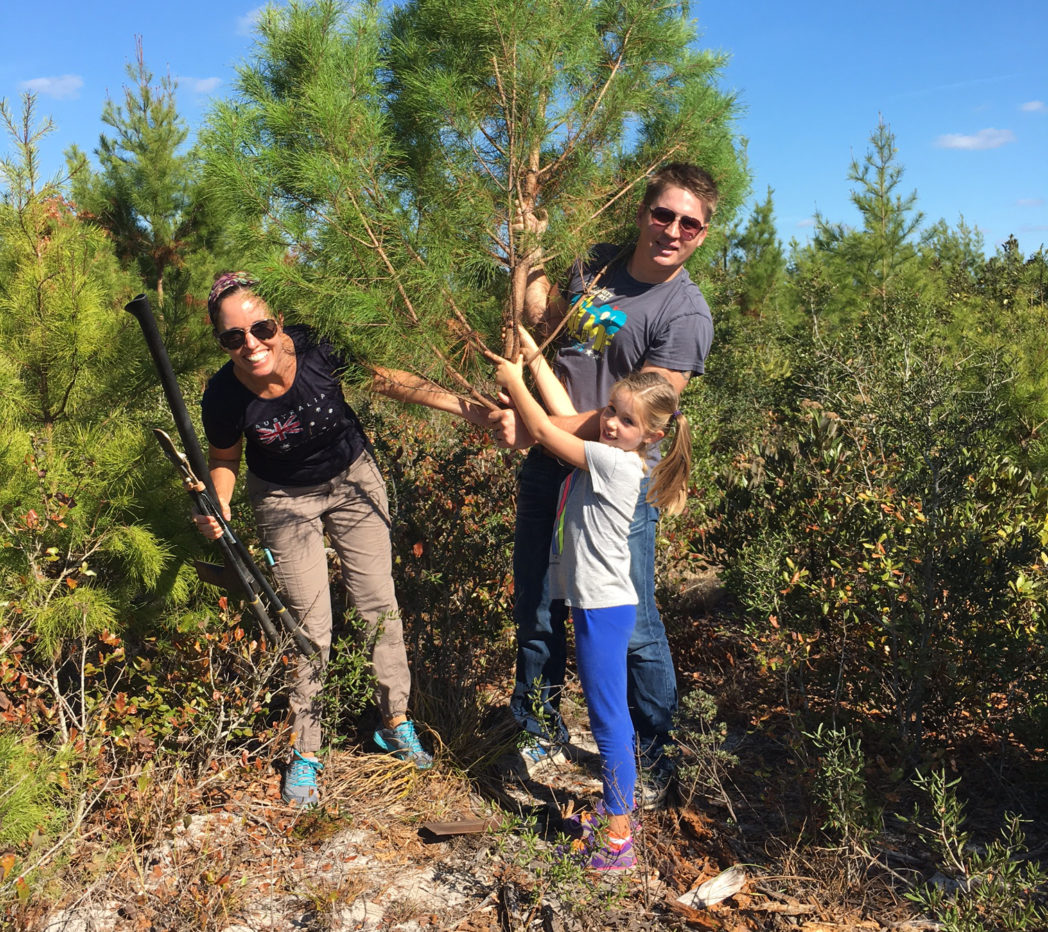 Family posing with cut sand pine