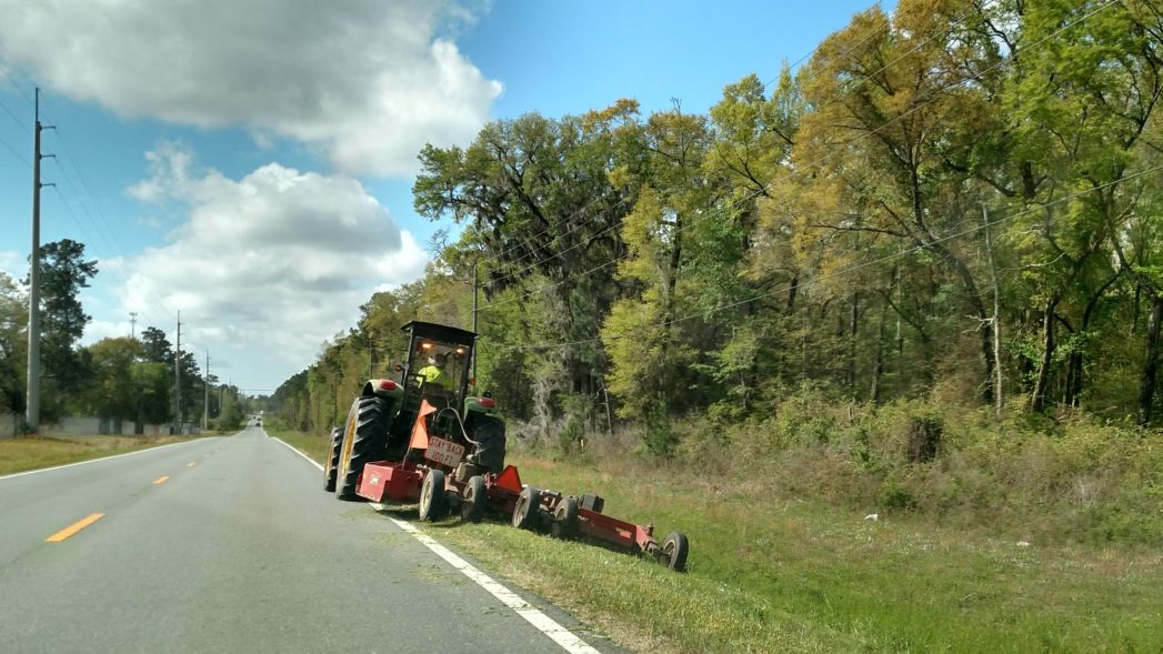 Industrial mower mowing along roadside