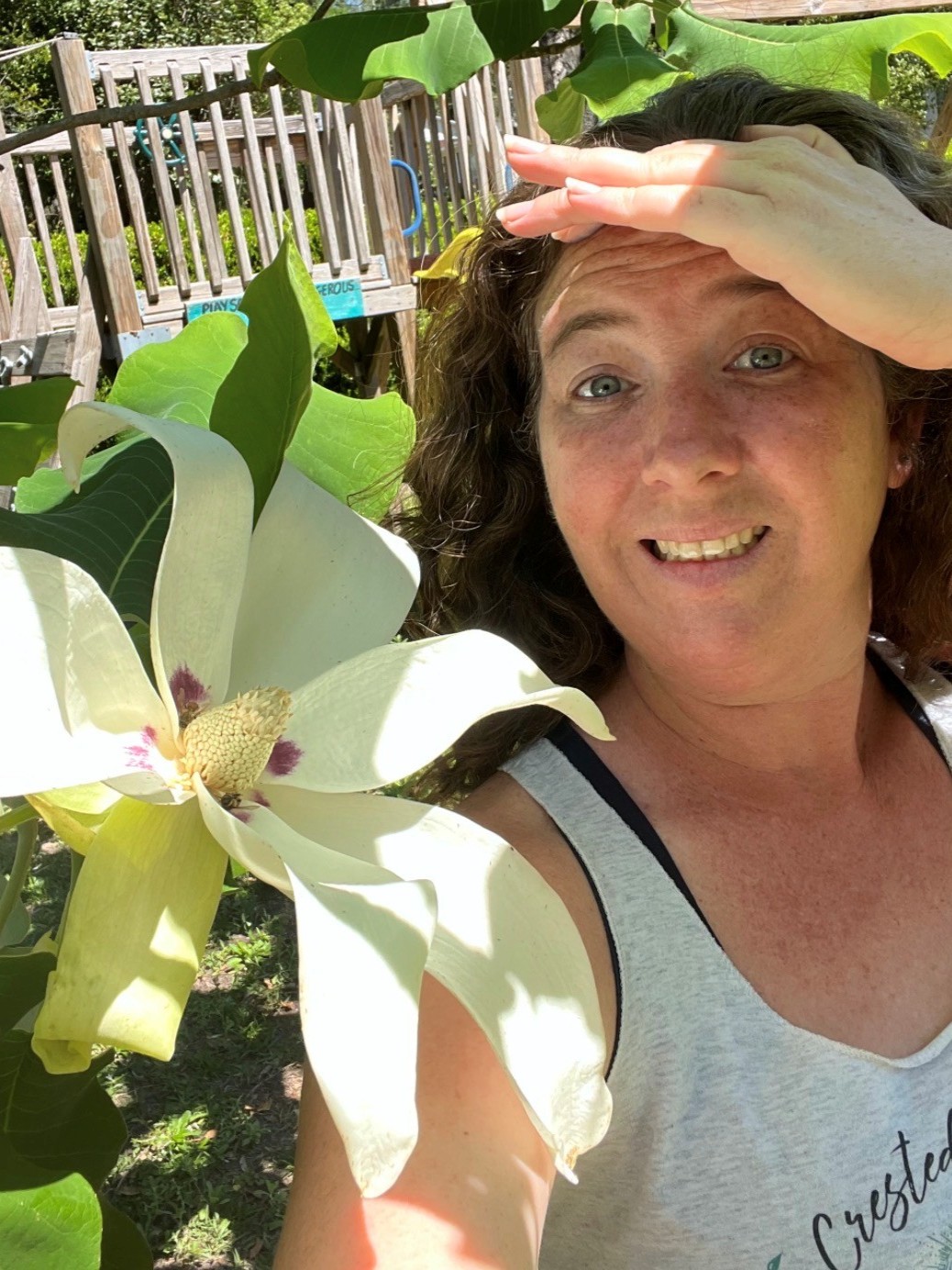 Foundation volunteer Kristy, posing with a magnolia. 
