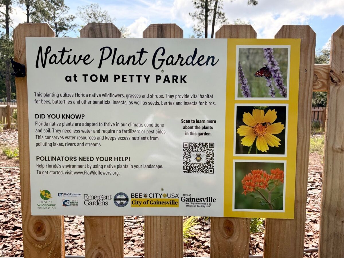 Sign about the Native Plant Garden at Tom Petty Park, describing its role in supporting pollinators, with plant photos, logos, and a QR code for more information.